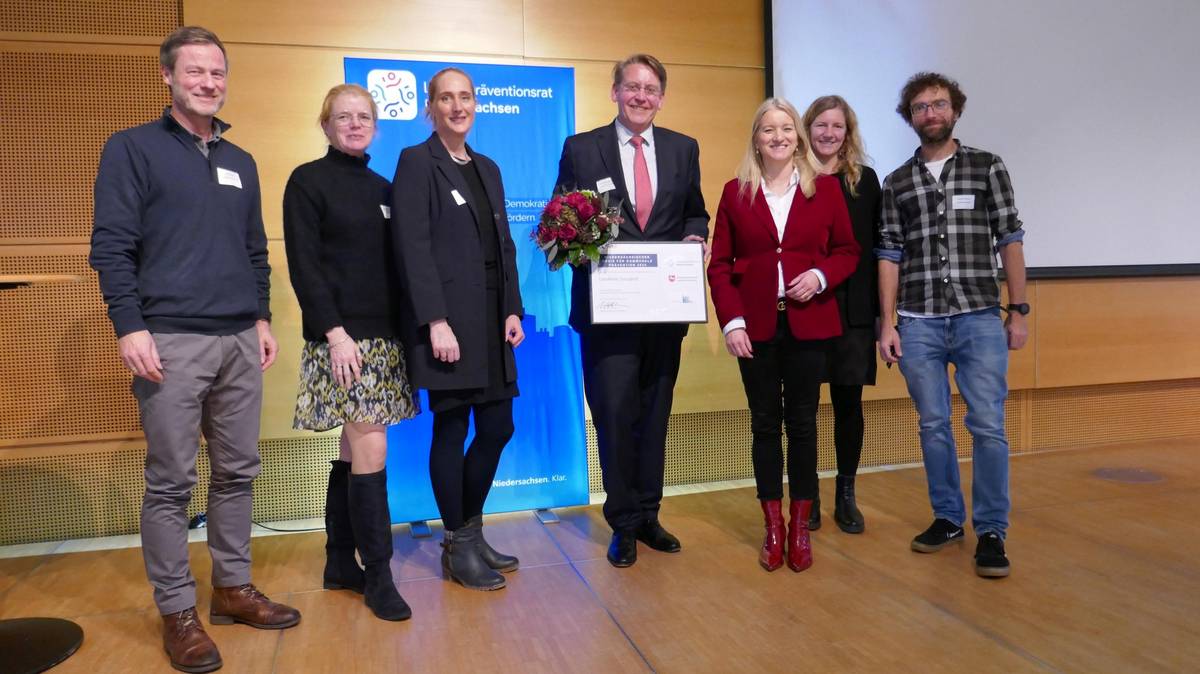 Ulrich Engling, Abteilungsleiter Jugendpflege, Kathrin Blome vom Landkreis Emsland, Katrin Stüllenberg von der Stüllenberg Stiftung, Landrat Marc-André Burgdorf, Ministerin Dr. Kathrin Wahlmann, Carolin Römer und Dominic Vähning vom Landkreis Emsland bei der Preisübergabe. (v. l., Foto: Landespräventionsrat Niedersachsen)